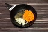 Шаг 4. В сковороду влить масло, добавить специи, морковь и лук. Пассеровать 5 ми