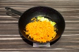 Шаг 4. В чугунной сковороде пассеровать морковь и лук в течение 2-3 минут.