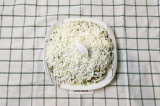 Шаг 5. Четвертым слоем выложить адыгейский сыр, натертый на крупной терке.