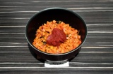 Шаг 7. Добавить томатную пасту и воду, размешать, накрыть крышкой и тушить