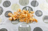 Шаг 3. Очистить мандарины и разделить их на дольки.