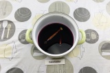 Шаг 3. Влить в кастрюлю виноградный сок, добавить специи и прогреть на медленном