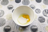 Шаг 3. В емкость для смешивания выложить яйцо, два желтка и оставшийся сахар.