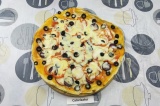 Шаг 11. Присыпать пиццу двумя видами натертого сыра и запекать еще 2 минуты.