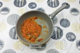 Шаг 4. В сковороду влить масло, добавить сухой чеснок, помидоры и базилик.
