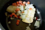 Шаг 1. На дно мультиварки высыпать нашинкованный лук и морковь.