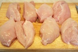 Шаг 1. Куриные грудки вымыть, обсушить и разрезать на две части.