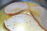 Шаг 4. Каждый ломтик хлеба обмакнуть в яичной смеси.