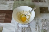 Шаг 1. Выложить в глубокую миску рикотту и добавить яйцо. Смешать до однородност
