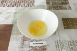 Шаг 1. В глубокую миску разбить два яйца, подсолить и взбить.
