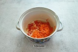 Шаг 4. В кастрюлю налить масло, 50 мл воды и выложить лук, морковь, помидор, сол