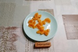 Шаг 4. Половину апельсина нарезать на крупные кусочки, из второй половины выдави