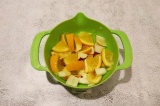 Шаг 4. В чашу сложить лимон, апельсин, яблоко, слегка раздавить.