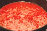 Шаг 5. В чистую сковороду добавить измельченную дольку чеснока и томаты в собст
