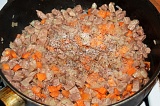 Шаг 4. Добавить лук к мясу и обжарить до золотистого цвета. Добавить морковь.