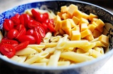 Шаг 6. Помидоры и сыр добавить к макаронам. Добавить заправку и посыпать базилик