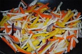 Шаг 8. Обжарить на воке имбирь, чеснок, добавить морковь, красный лук, капусту.