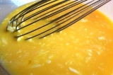 Шаг 4. Яйца взбить, добавить сыр и остывшее масло.