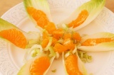 Шаг 4. Выложить кусочки мандарина на листья цикория.