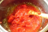 Шаг 5. Добавить помидоры к луку. Влить куриный бульон.