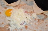 Шаг 4. Разбить на лаваш яйцо, положить индейку и посыпать сыром.