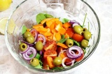 Шаг 6. Добавить овощи, шпинат и оливки в салатник, заправить маслом и сбрызнуть