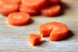 Шаг 2. Из каждого морковного кружочка вырезать небольшой треугольничек.