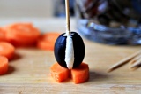 Шаг 4. Закрепить оливку на морковном кружке с помощью зубочистки.
