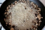 Шаг 4. В сковороду с луком и грибами добавить рис. Готовить блюдо, подливая воду