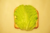Шаг 4. Хлеб намазать маслом, сверху положить лист салата.