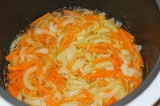 Шаг 3. Включить мультиварку и обжарить на масле лук, а потом добавить морковь.