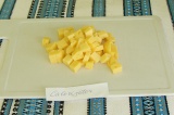 Шаг 4. Сыр нарезать кубиками, немного меньше, чем кабачки и хлеб.