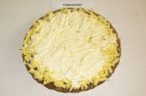 Шаг 5. На плоскую тарелку выложить тертый сыр и смазать майонезом.