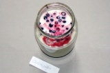 Шаг 1. В емкость вылить йогурт. Добавить размороженные ягоды.