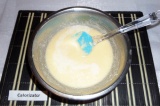 Шаг 3. Постепенно влить яйца в масляную смесь, постоянно помешивая. Влить молоко