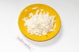 Шаг 6. Плавленый сыр натереть на крупной терке и добавить в соус. Перемешать