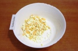 Шаг 2. Сваренные яйца остудить в холодной воде, очистить и мелко нарезать.