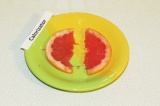 Шаг 5. Разрезать дольку грейпфрута на две части. Одну положить в коктейль, второ