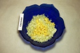 Шаг 2. Сыр порезать мелкими кубиками и добавить к капусте.