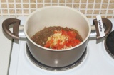 Шаг 4. Добавить чеснок и помидор к чечевице и варить еще 10 минут.