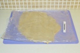 Шаг 4. Раскатать тесто на силиконовом коврике под пленкой.