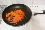 Шаг 1. Натереть морковь на терке и жарить на сухой сковороде в течение 3-4 минут