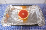 Шаг 1. Выложить грейпфрут на противень с фольгой или пергаментной бумагой.