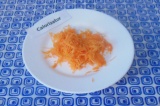 Шаг 2. Натереть на мелкой терке морковь, выложить в тарелку.