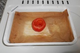 Шаг 4. Выстелить бумагу на противень, выложить помидор.
