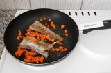 Шаг 3. Нарезать морковь мелкими кубиками и добавить к минтаю. Жарить еще несколь