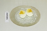 Шаг 7. Почистить яйца и порезать на половинки.