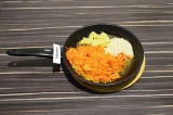 Шаг 4. Выложить в сковороду имбирь, морковь и кунжут. Пассеровать до золотистого