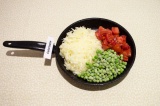 Шаг 6. В сковороду добавить патиссон, помидор и зеленый горошек. Подсолить и туш