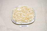 Шаг 2. Второй слой – натереть на крупной терке копченый адыгейский сыр, подсолит
